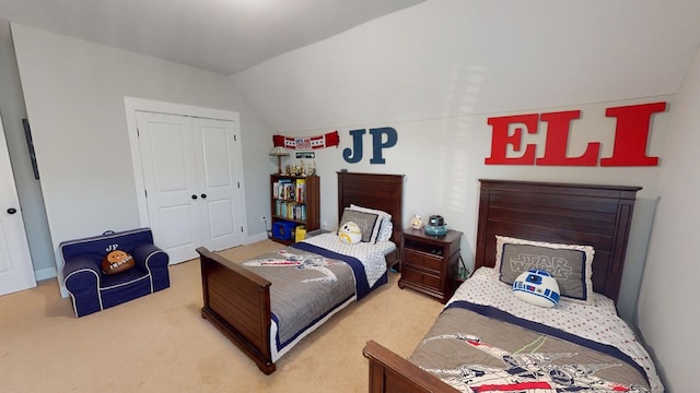 bedroom with lofted ceiling, carpet flooring, and a closet