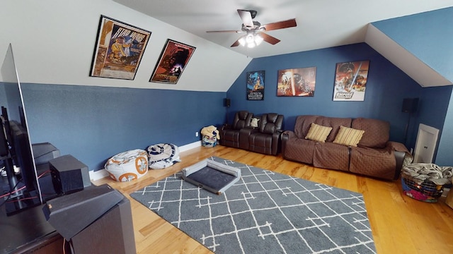 cinema room featuring wood-type flooring, ceiling fan, and vaulted ceiling