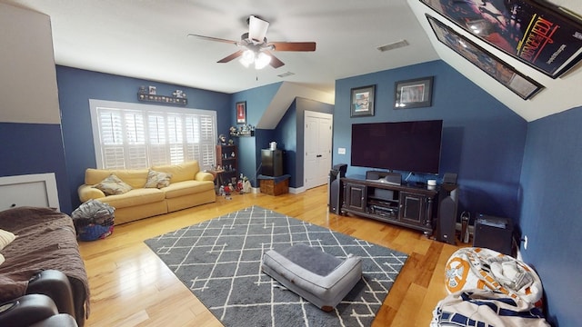 living room with hardwood / wood-style flooring, vaulted ceiling, and ceiling fan