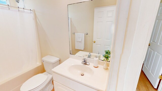 full bathroom featuring hardwood / wood-style flooring, vanity, toilet, and tub / shower combination