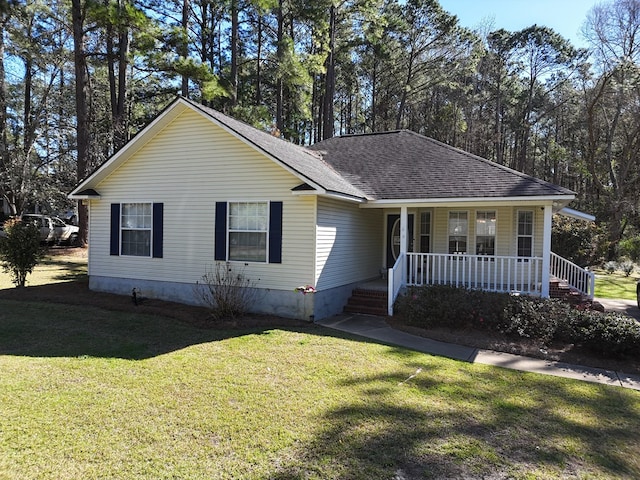 view of front of home with a shingled roof, covered porch, and a front lawn