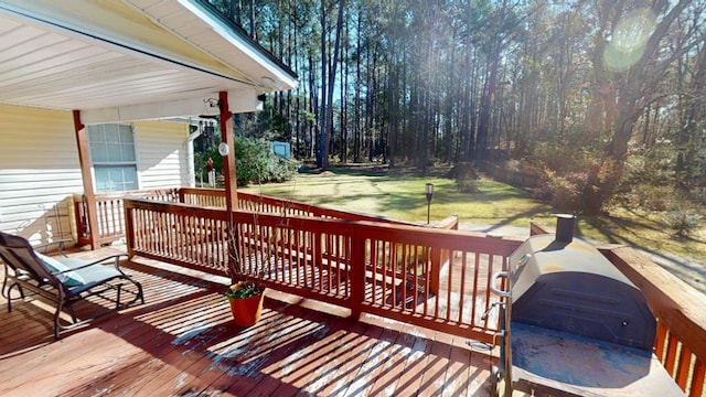 wooden terrace featuring a grill and a lawn