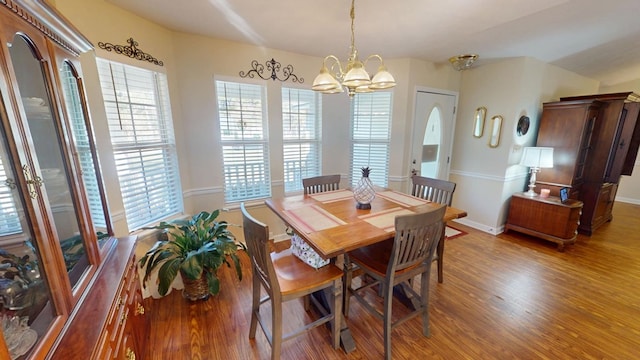 dining area featuring a wealth of natural light, baseboards, a chandelier, and wood finished floors