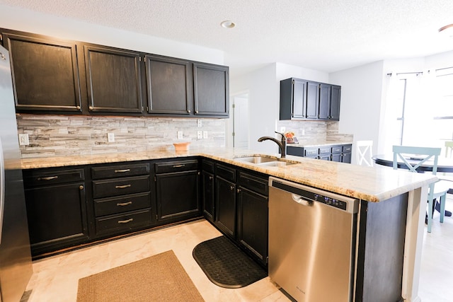 351 Plantation Ln, Thomasville, GA 31757 - kitchen with stainless steel appliances, tasteful backsplash, a peninsula, a textured ceiling, and light stone countertops
