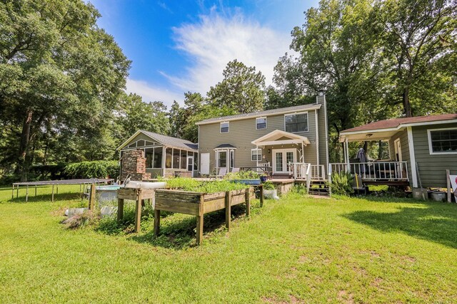 351 Plantation Ln, Thomasville, GA 31757 - back of property featuring a trampoline, a sunroom, a deck, a chimney, and french doors
