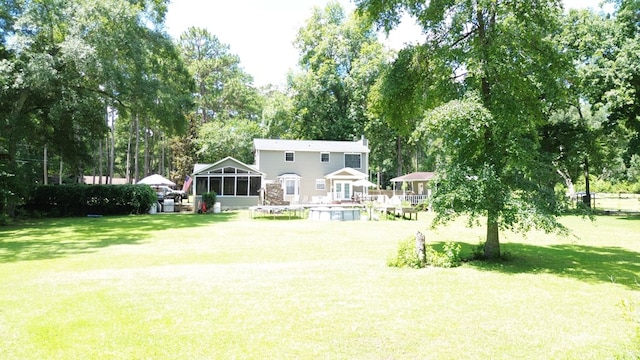 351 Plantation Ln, Thomasville, GA 31757 - rear view of property featuring a sunroom, a lawn, and view of wooded area