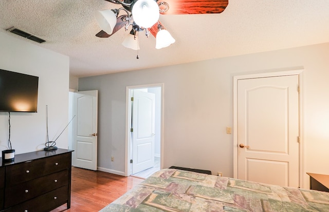 351 Plantation Ln, Thomasville, GA 31757 - bedroom featuring wood finished floors, a textured ceiling, connected bathroom, and a ceiling fan