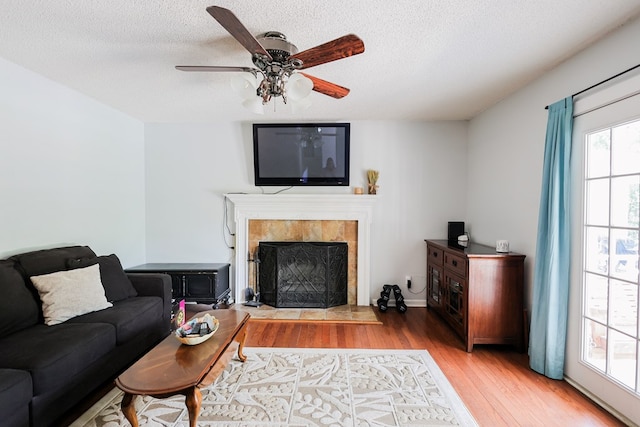 351 Plantation Ln, Thomasville, GA 31757 - living area with wood finished floors, a textured ceiling, a ceiling fan, and a fireplace