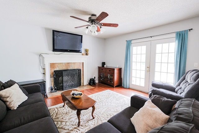 351 Plantation Ln, Thomasville, GA 31757 - living area with a ceiling fan, wood finished floors, a textured ceiling, a fireplace, and french doors
