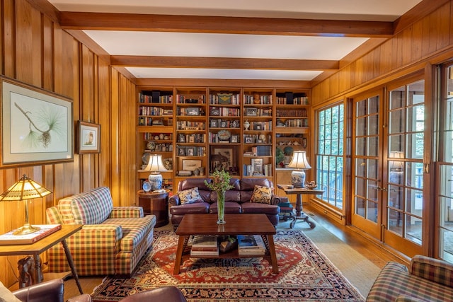 living area with beam ceiling and wooden walls