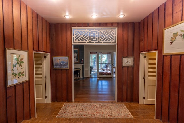 hallway featuring wood walls