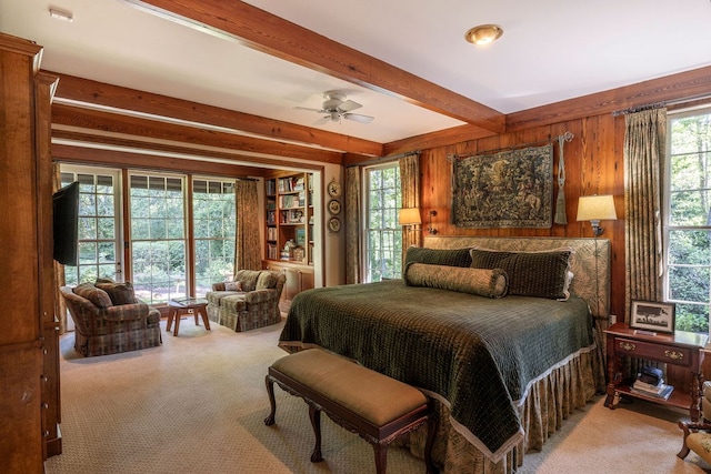 bedroom with beamed ceiling, carpet flooring, and wooden walls