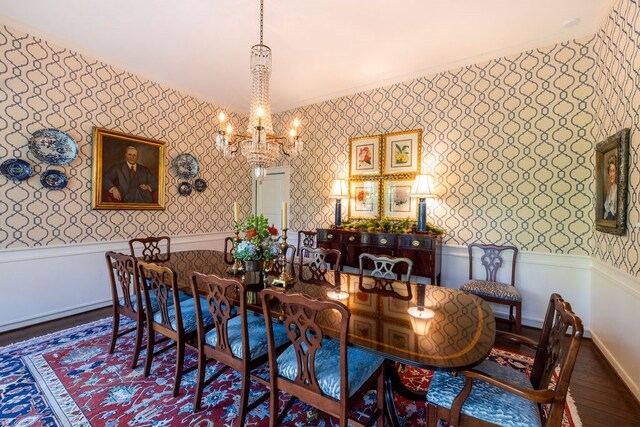 dining space featuring ornamental molding, wood-type flooring, and a notable chandelier