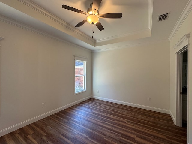 unfurnished room featuring a raised ceiling, crown molding, ceiling fan, and dark hardwood / wood-style flooring