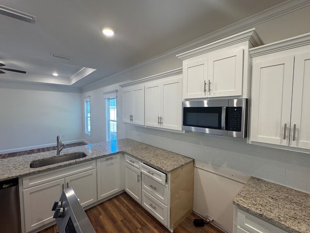 kitchen featuring a raised ceiling, sink, white cabinets, ornamental molding, and stainless steel appliances