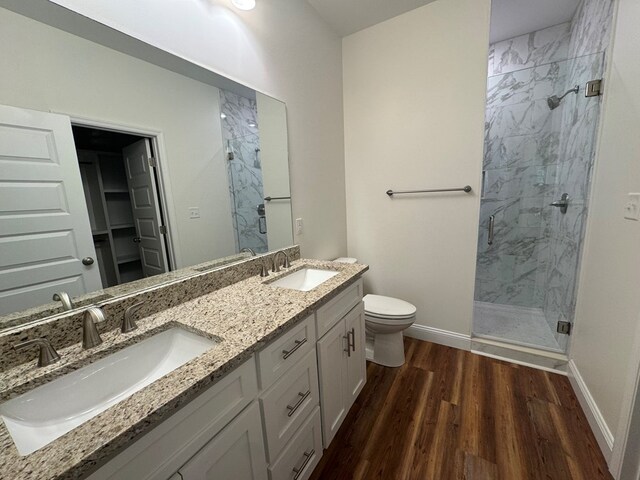 bathroom with wood-type flooring, toilet, an enclosed shower, and vanity