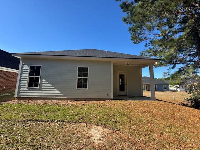 rear view of house featuring a yard