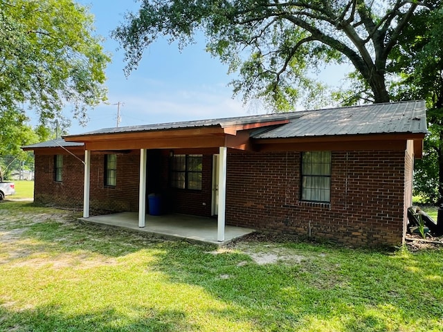 back of house featuring a yard and a patio area