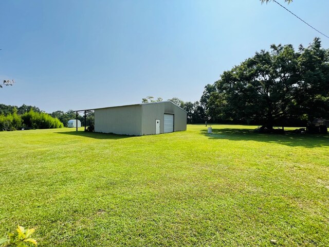 view of yard featuring a garage and an outbuilding