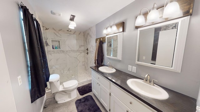 bathroom featuring vanity, toilet, and tiled shower