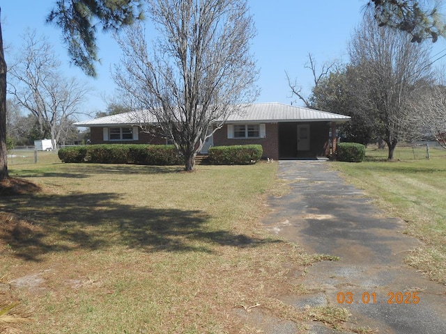 ranch-style house featuring a carport, a front yard, and driveway