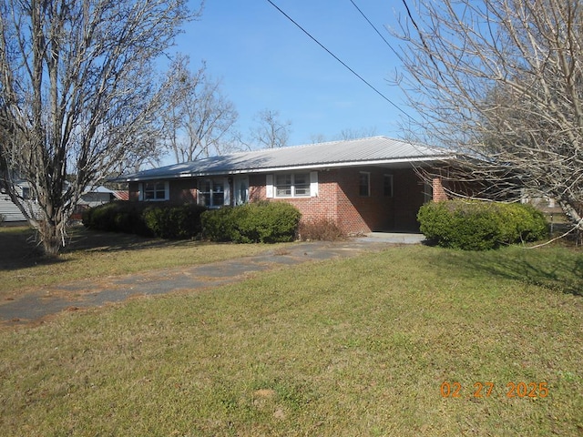 ranch-style home with driveway, a front yard, a carport, and brick siding