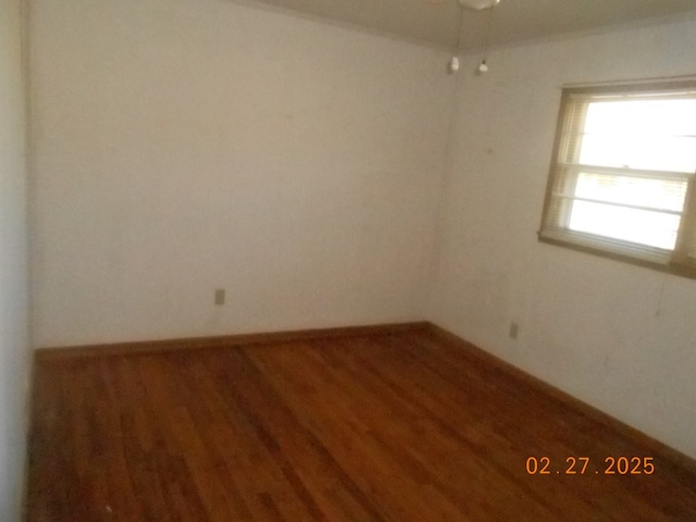 unfurnished room featuring baseboards and wood finished floors