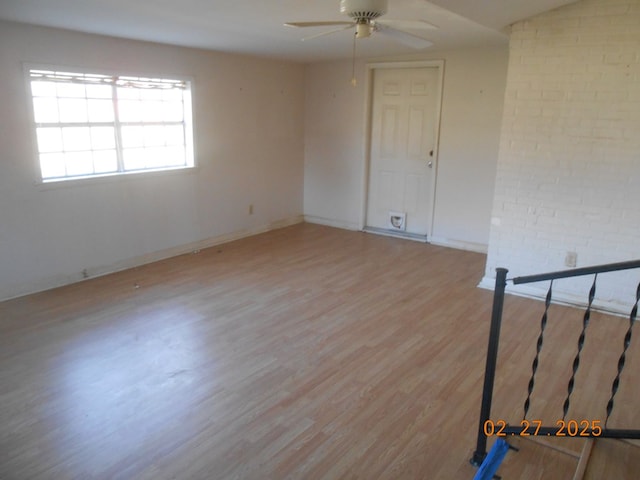 unfurnished room featuring light wood finished floors, baseboards, and a ceiling fan