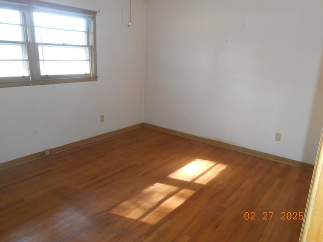 empty room featuring wood finished floors and baseboards