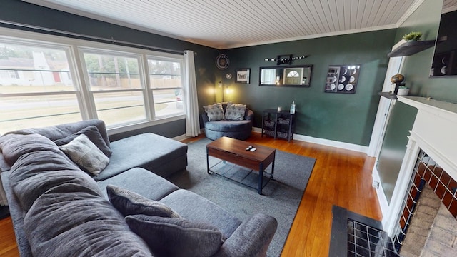 living area featuring wooden ceiling, a fireplace, wood finished floors, baseboards, and crown molding