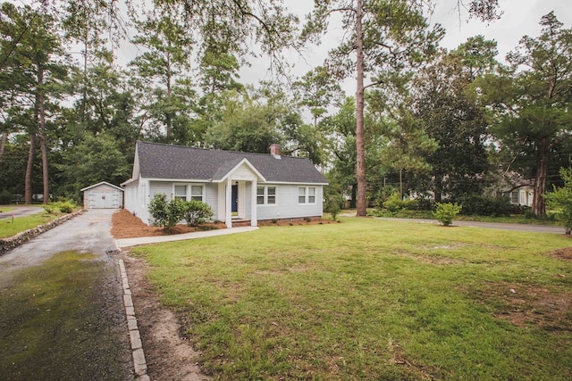 ranch-style house with a garage, an outbuilding, and a front yard