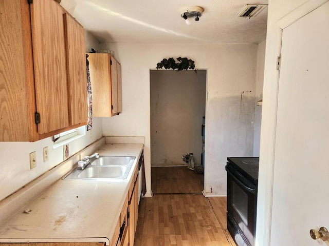 kitchen featuring black range with electric stovetop, sink, and light hardwood / wood-style floors