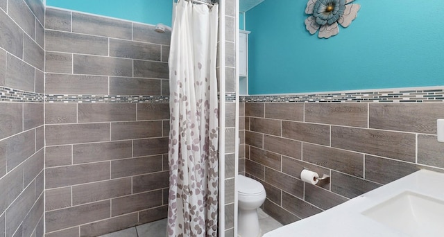 full bathroom featuring a wainscoted wall, a tile shower, tile walls, and toilet