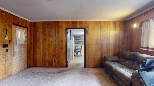 living area with ornamental molding, light colored carpet, and wooden walls