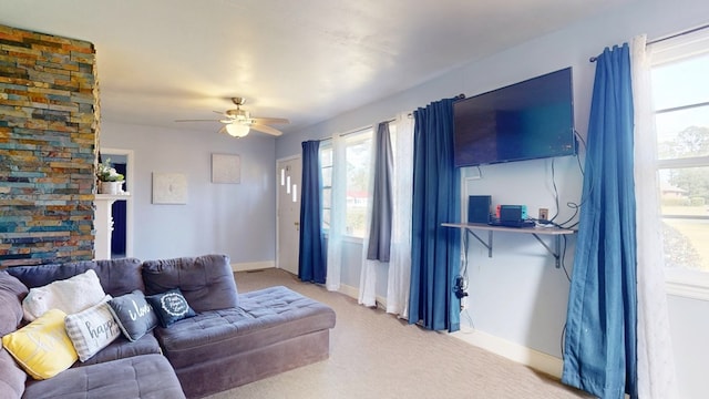 carpeted living room featuring baseboards and a ceiling fan