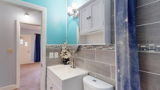 bathroom featuring toilet, tile walls, and vanity