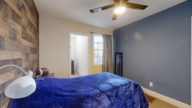 bedroom with an accent wall, a fireplace, a ceiling fan, and baseboards