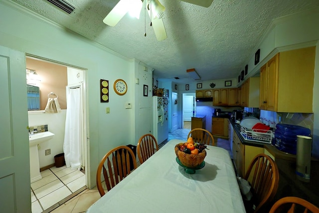 dining area featuring light tile patterned floors, ceiling fan, and a textured ceiling