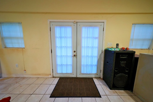 entryway with light tile patterned floors, french doors, plenty of natural light, and baseboards