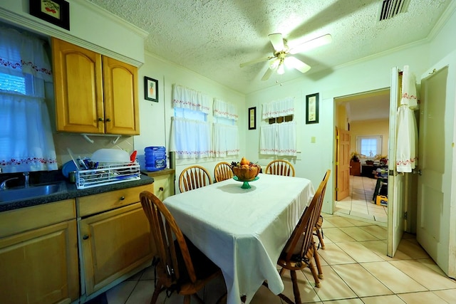 dining area with crown molding, visible vents, a textured ceiling, and light tile patterned flooring