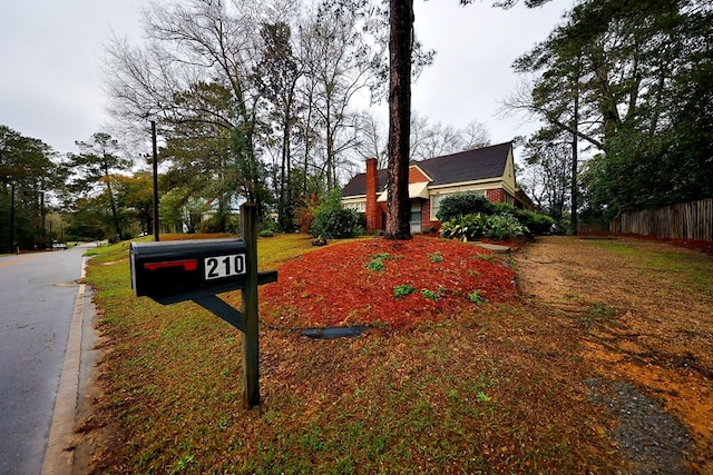 view of front of house with brick siding, fence, and a chimney