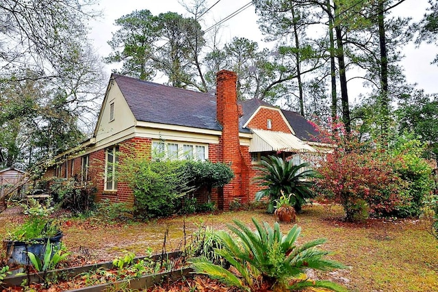 exterior space featuring brick siding and a chimney