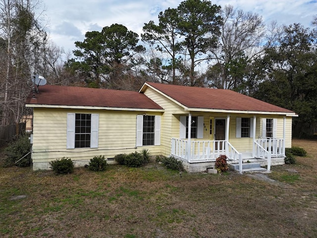 ranch-style house featuring a front yard and covered porch