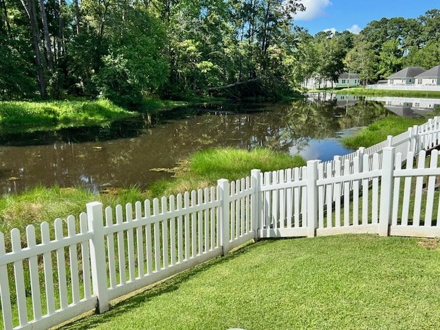 view of yard with fence and a water view
