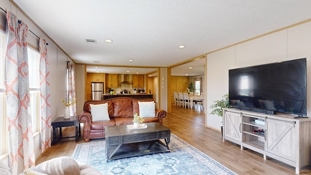 living area with recessed lighting, visible vents, and light wood-style flooring