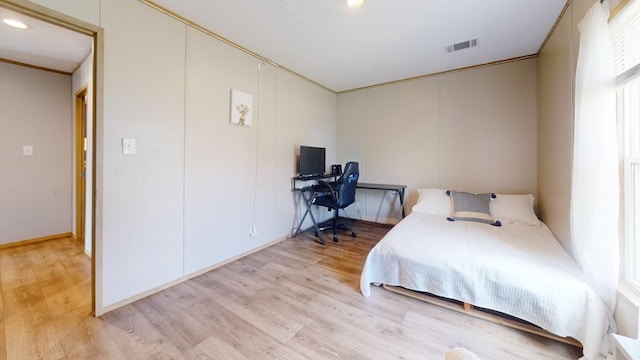 bedroom featuring crown molding, visible vents, multiple windows, and light wood-type flooring