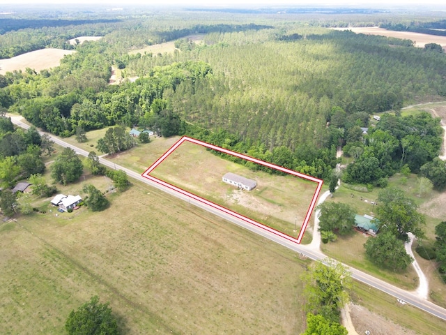 birds eye view of property featuring a view of trees
