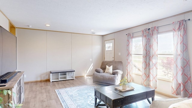 living room with crown molding, recessed lighting, baseboards, and light wood-type flooring