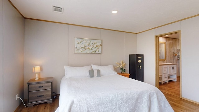 bedroom with crown molding, visible vents, and wood finished floors