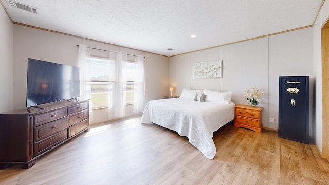 bedroom featuring visible vents, ornamental molding, light wood finished floors, and recessed lighting